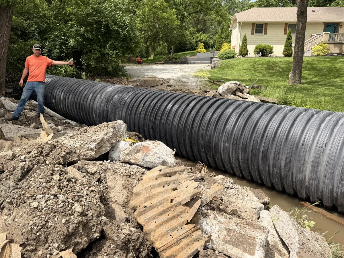72-inch HDPE culvert pipe staged next to the old failed metal culvert